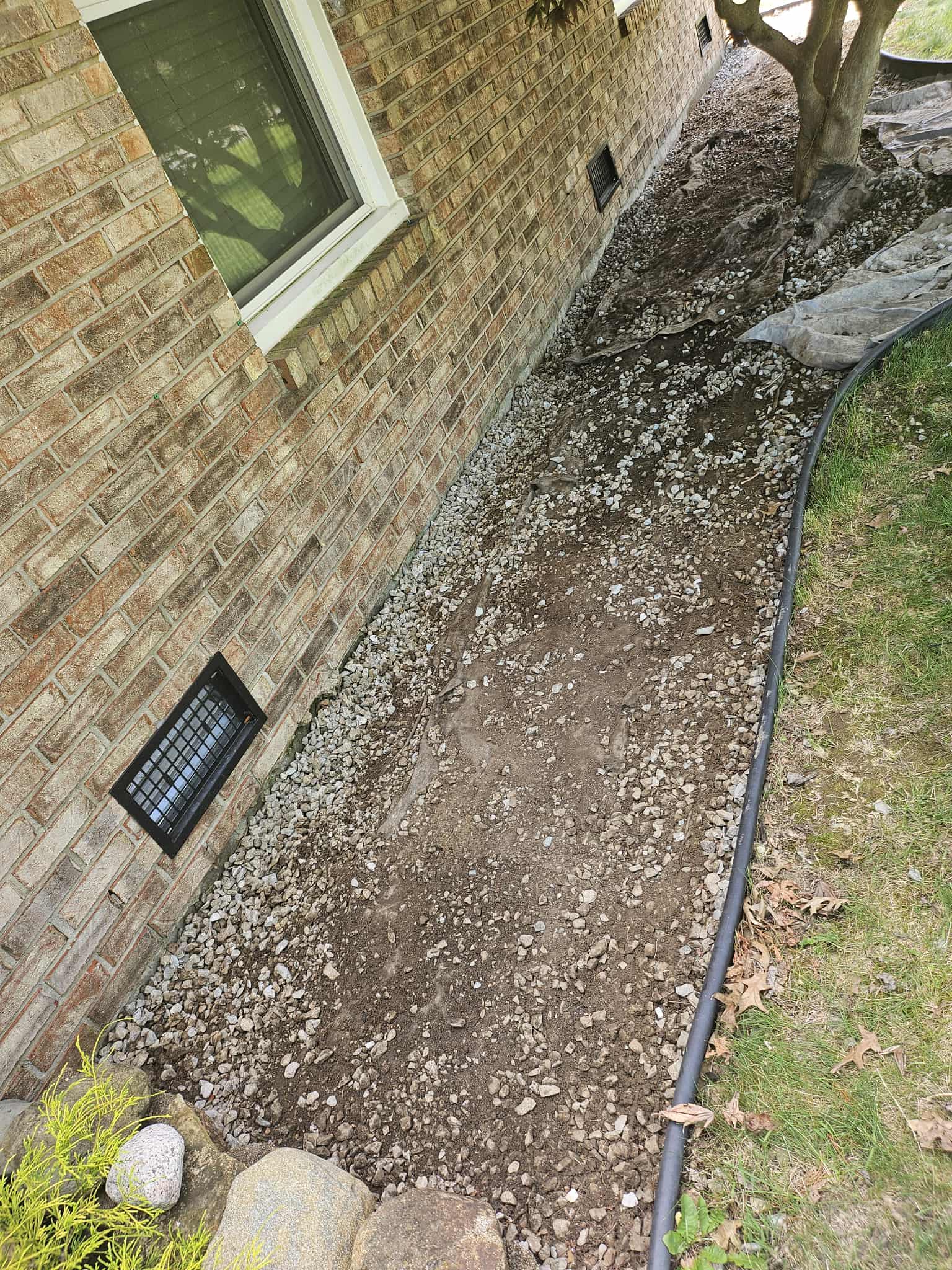 Side yard cleared of gravel and debris